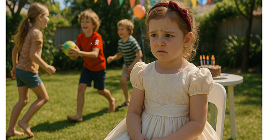 Sad girl in a party dress sitting alone at a birthday party while other kids play – highlighting the importance of inclusive kids’ fashion and comfort.